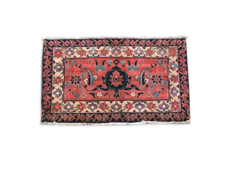 A Persian vagireh or sampler rug, possibly Lillian, late 20th century, with central lotus flower motif on a pale madder groun