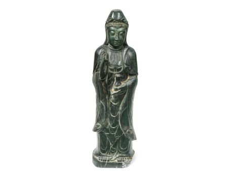 A large Chinese spinach jade carved standing figure of Guanyin,  The Bodhisattva of mercy with one hand held in mudra, the ot