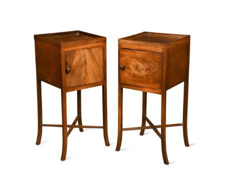 A pair of mahogany bedside cupboards, 19th century, the galleried tops over single cupboard doors with turned handles, raised