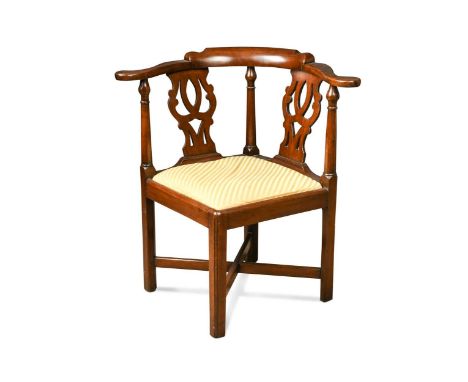 A George III mahogany corner chair, the flat outscrolled arms over pierced vase shaped back splats above a drop in seat on sq