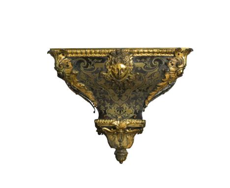 A Boullework and ormolu mounted clock bracket, 19th century with central mask motif above tapering base 30cm high, 38cm wide