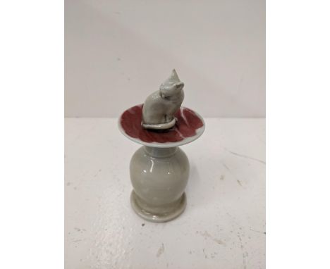 A ceramic lipped cent bottle fashioned as a cat on a plinthLocation: If there is no condition report, please request.