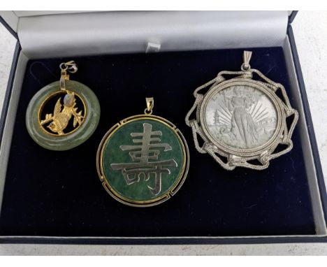 A Chinese jade disc pendant, gilt metal mounts with bird and leaf decoration to the centre, set with an oval opal and a black