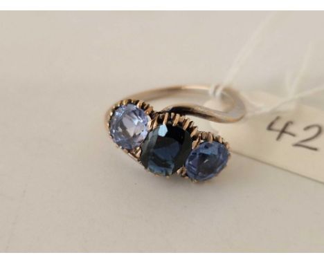 A three stone dark blue and light blue gemstone ring, set in gold size N, 3.6 g