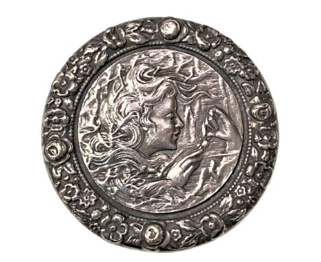 1 Very large early 20th century silvered brass female head button.Art Nouveau flowing haired female smelling a flower. The bo