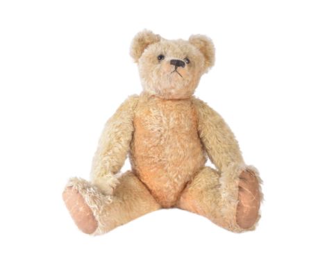 A vintage English soft toy teddy bear with squeaker. Likely a Chad Valley / Chiltern example with golden mohair, stitched nos