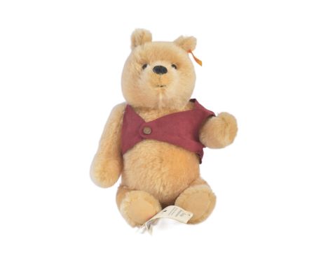 An original vintage German Steiff made soft toy teddy bear 'Winnie The Pooh'. Complete with original tunic and button. Steiff