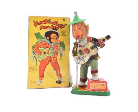 A vintage Japanese (Alps) made tinplate Rock n Roll musical Monkey. Battery operated with a light up microphone and guitar pl
