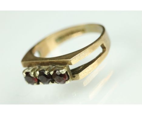 Garnet 9ct gold three stone ring, three small round mixed cut garnets, claw set, openwork tapered shoulders, ring size K½ 