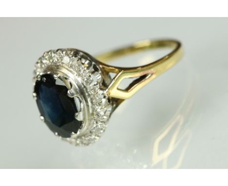 Sapphire and diamond halo dress ring being set with an oval cut blue sapphire with a halo of round cut diamond accent stones,