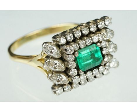 Emerald and diamond 18ct yellow and white gold cluster ring, the central emerald cut emerald measuring approx 6mm x 5mm, claw