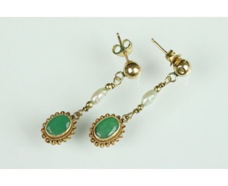 Emerald and freshwater pearl yellow metal drop earrings, the oval mixed cut emerald measuring approx 6.5 x 4.5mm, rubover set