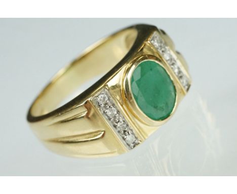 Emerald and diamond 9ct yellow gold Gents ring, the oval mixed cut emerald measuring approx 9mm x 7mm, rubover set, eight sma