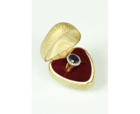 Amethyst and diamond dress ring having a large oval cut amethyst to the centre set with a halo of round cut diamonds, with ca