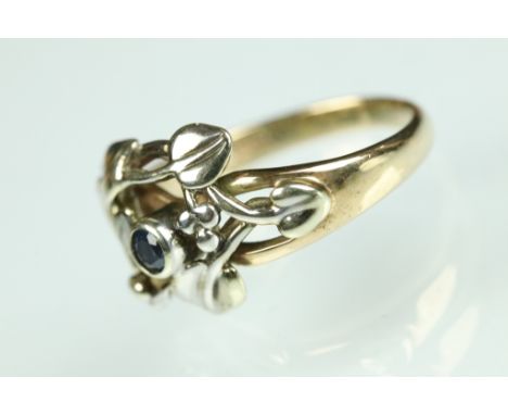 Sapphire 9ct yellow and white gold ring, small round cut sapphire to centre, openwork vine design, tapered shoulders, ring si