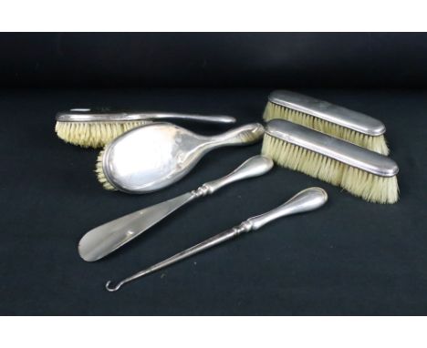 Edwardian silver backed dressing table set consisting of two hair brushes, two clothes brushes, a shoe horn and a button hook