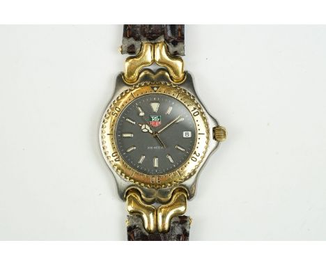 Tag Heuer chronograph wrist watch having a black face with luminous baton markers and date aperture to three. Marked water re