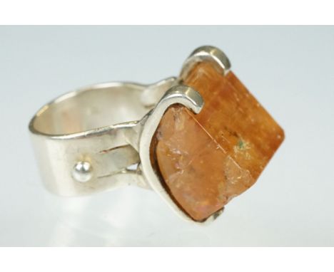 Gem set silver ring, the faceted asymmetric orange stone probably orange topaz, dimensions approx 17mm x 16mm x 14mm, claw se