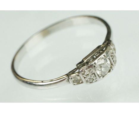 Art Deco diamond solitaire white metal ring, the round old cut diamond weighing approx 0.15 carat, claw and rubover set, six 