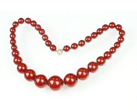 1930s cherry bakelite beaded necklace having graduating round beads and a spring ring clasp. Measures 18 inches. largest bead