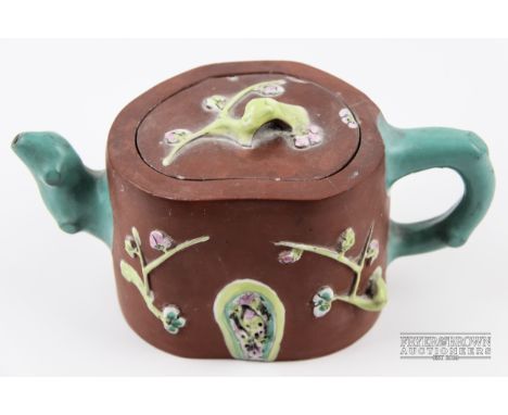 A Chinese Yixing enamelled teapot &amp; cover, decorated with prunus and rockwork, turquoise coloured crabstock handle and sp