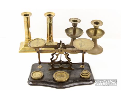 A pair of brass dwarf candlesticks, with internal ejectors; a part set of postage scales; and another pair of brass finish ca