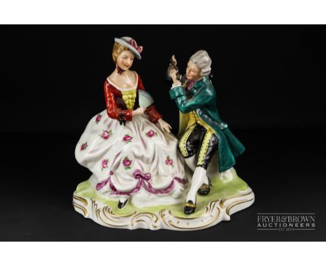 A figural group of a seated courting couple, she with fan and he playing a pipe, faux Dresden ark to base, 26cm high max. app