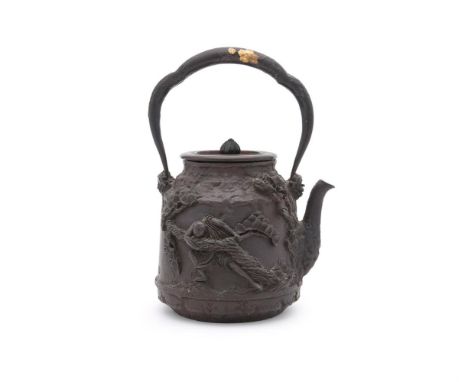 A Japanese Cast Iron Tetsubin, of tapering cylindrical form with short spout and overhead handle, decorated in high relief to