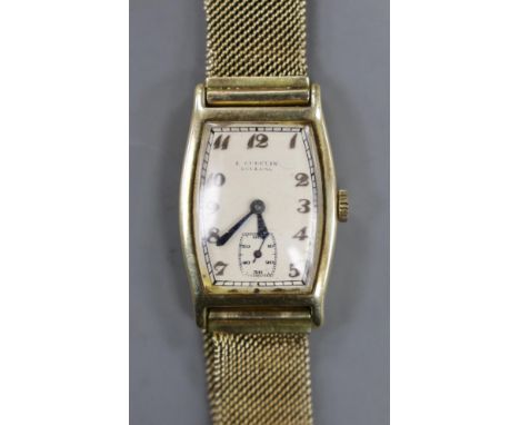 A gentleman's 14k tonneau shaped manual wind wrist watch, retailed by E. Cubelin, with Arabic dial and subsidiary seconds, on