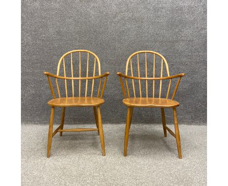 A pair of mid century Ercol style beech and elm Windsor chairs with impressed Utility Scheme furniture marks to the base. (On