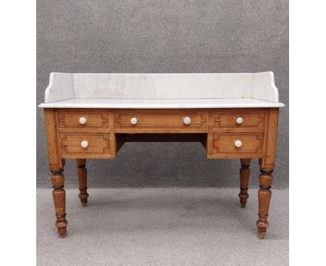 A Victorian pine washstand having a white marble top with a shaped gallery back over an arrangement of five hand painted draw