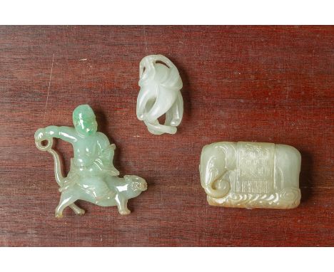 A GROUP OF THREE JADE CARVINGS Comprising a celadon and russet jade toggle in the form of an elephant, a model of a male figu