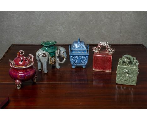 A GROUP OF ORIENTAL CERAMIC ITEMS Comprising a square moulded seal with dragon finial, a model of an elephant, two covered se