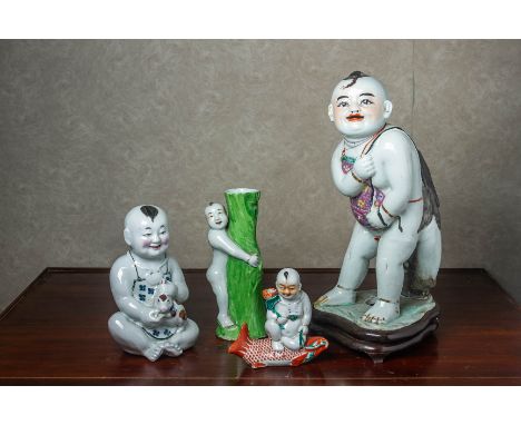 A GROUP OF PORCELAIN FIGURES OF BOYS Comprising a large example carrying a large fish over his back, another of a seated figu