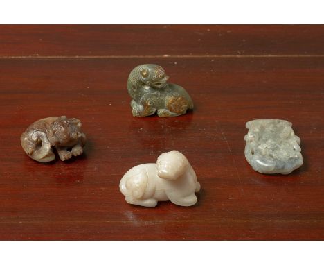 A GROUP OF FOUR JADE CARVINGS Three modelled as recumbent beasts, their heads turned to one side and one in the form of a axe