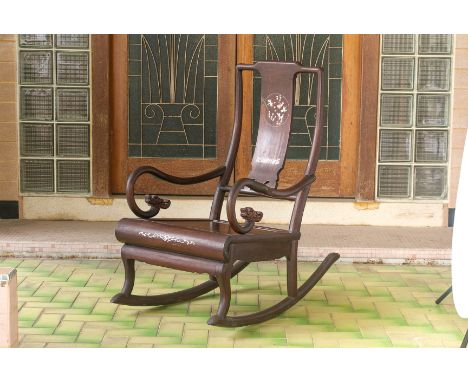 A MOTHER OF PEARL INLAID BLACKWOOD ROCKING CHAIR
With dragon head scroll arms, the splat decorated with goldfish amongst aqua