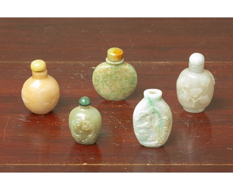 A GROUP OF FIVE CARVED JADE SNUFF BOTTLES Including an example carved in relief with foliage, one with a landscape, another w