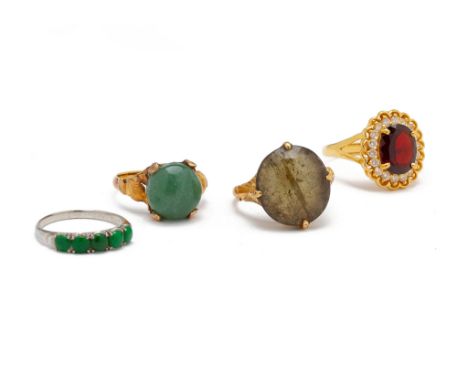 A GROUP OF FOUR GEM SET RINGS
Comprising: an 18k white gold and jade ring, set with five jade cabochons; a garnet and paste c