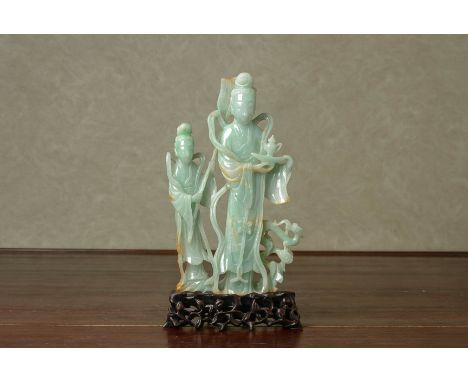 A CARVED JADE MODEL OF FIGURES
The larger female figure holding a tea pot with an attendant beside and a small dragon at her 