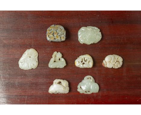 A GROUP OF EIGHT JADE CARVINGS Including a grey and russet jade plaque carved with a stylised bat, mounted as a belt buckle, 