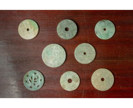 A GROUP OF EIGHT CARVED JADE DISKS
Mostly with shallow carved decoration of flowers, bats, another with archaic calligraphy
L