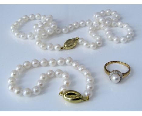 An 18ct diamond and pearl halo ring, size O, together with a cultured pearl matching necklace and bracelet with stylised 18ct