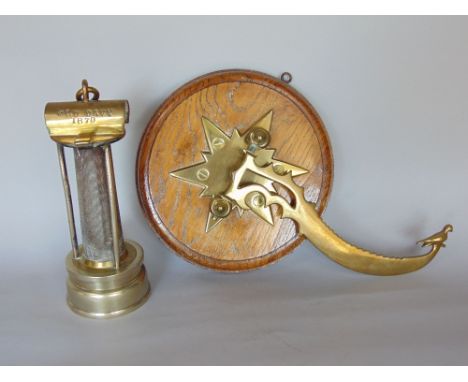 A 19th century brass miners type lamp inscribed Old Davy 1870, together with a further brass and oak hinged wall bracket moun