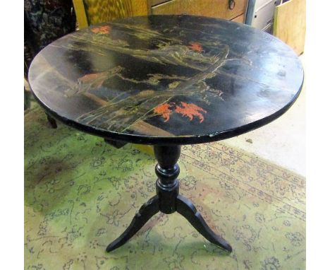 An ebonised and black lacquered snap top occasional table of circular form with chinoiserie detail raised on a central turned