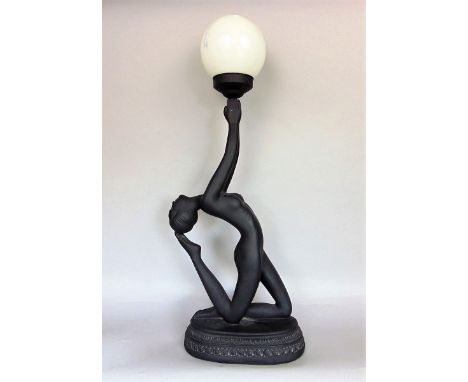 An art deco style ebonised plaster figural table lamp in the form of a nude, holding an opaline glass globular shade, 76cm hi