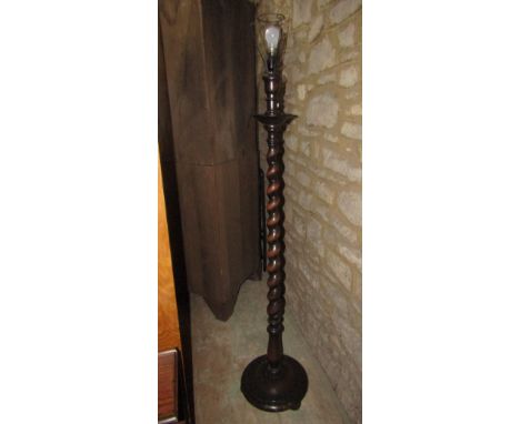 An oak standard lamp with spiral twist column and disc shaped platform base