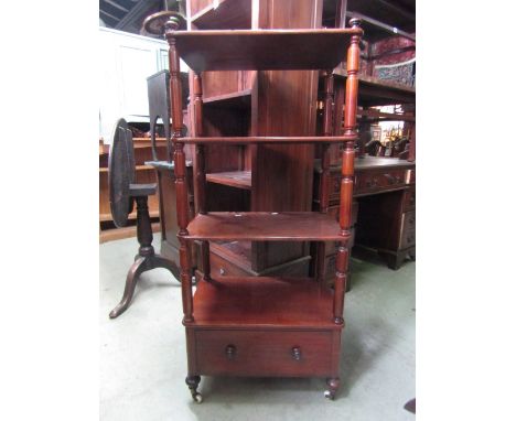 A Victorian mahogany whatnot on four rectangular tiers with turned column supports and drawer to base and raised on turned su