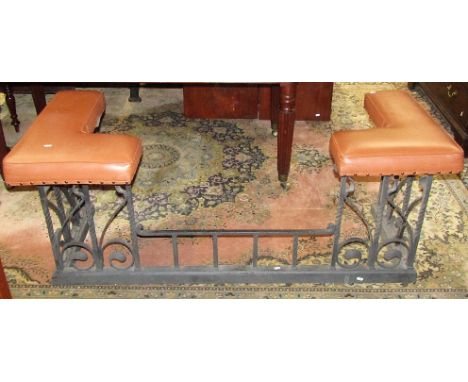A good quality cast iron club fender in the art nouveau style with painted finish, supporting two leather upholstered corner 
