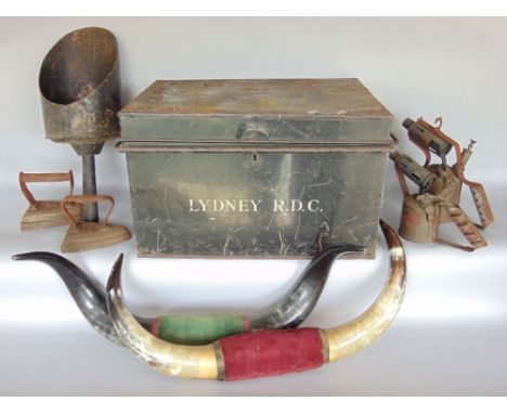 A military tin trunk containing a collection of miscellaneous items to include two set of cow horns, a coal scoop, blow torch