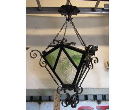 An ironwork hanging ceiling light enclosing art deco style leaded light panels